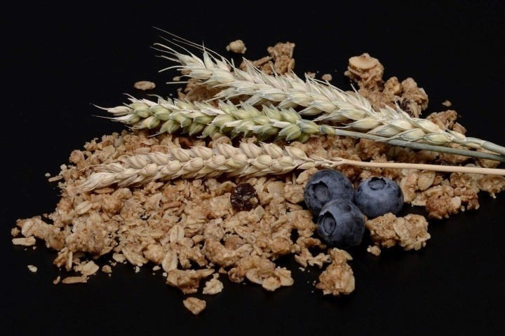 Колосья пшеницы и зерновые хлопья на черном фоне