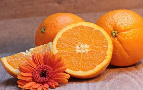 Апельсины и цветок на столе